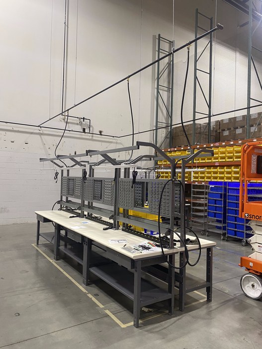 Overhead piping and air line drops feeding assembly workstations in a warehouse